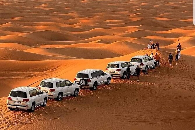 Tourists enjoying a thrilling Red Dune Desert Safari in Dubai with golden sand dunes in the background.